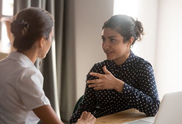 Two colleagues having a difficult conversation effectively as they listen to each other with open minds and understanding. 