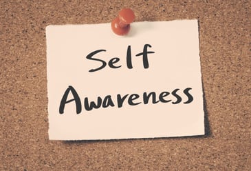 The words Self Awareness written on a piece of paper and pinned to a cork board by a business owner as they upskill this soft skill to better their role in leadership. 