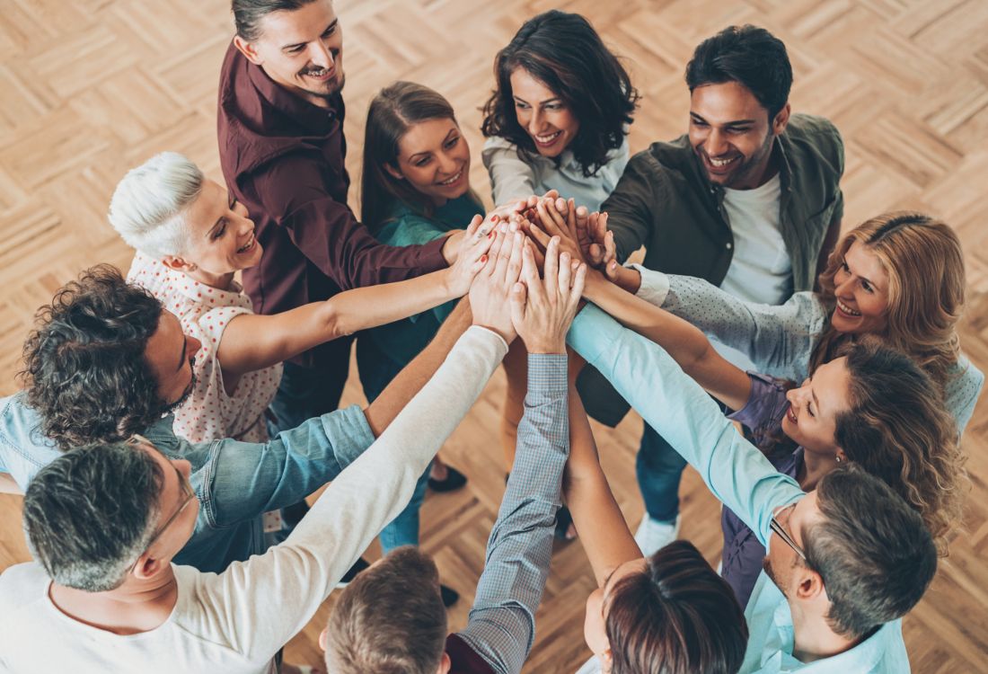 A successful team having a group high five as they celebrate the achievements they done together due to their effective teamwork.