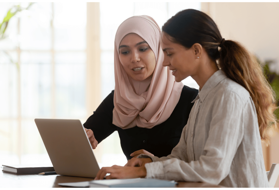 Two female employees working on their personal development together after being encouraged to by their company.