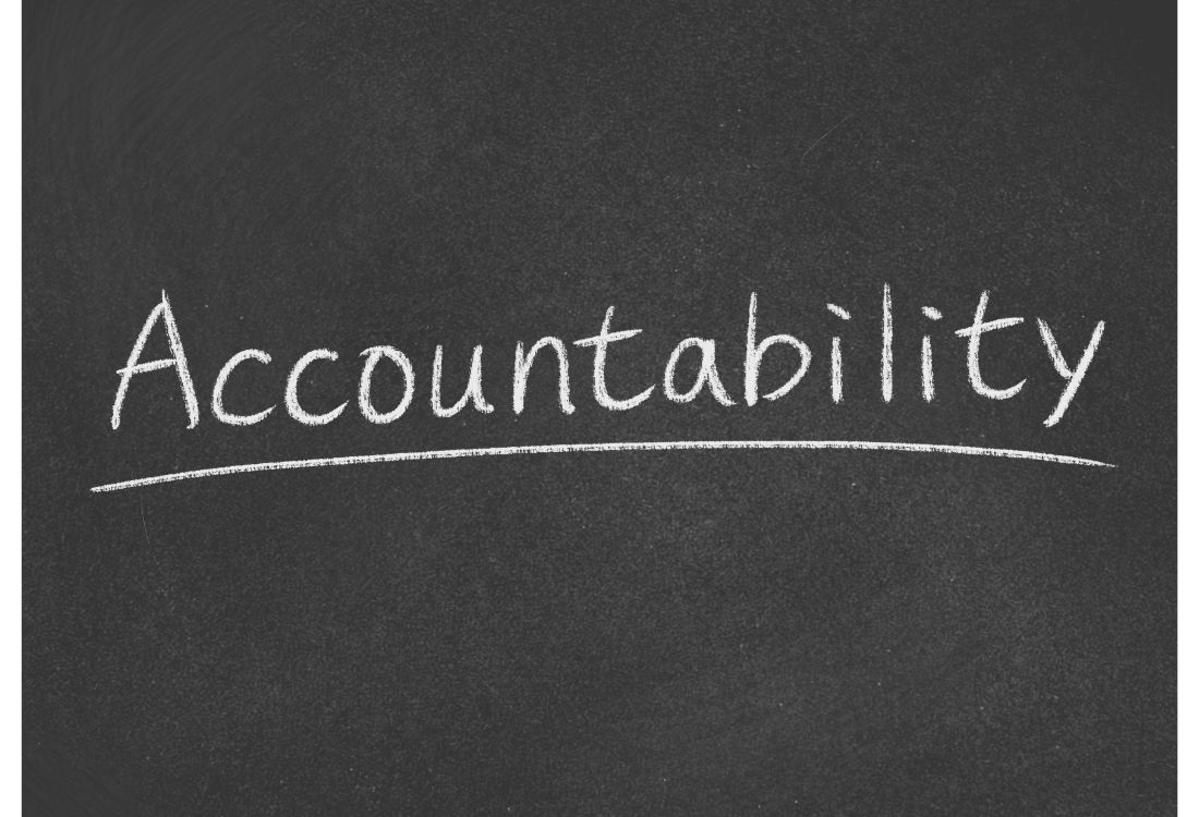 The word accountability written in white chalk on a black board explaining why accountability is important within management. 